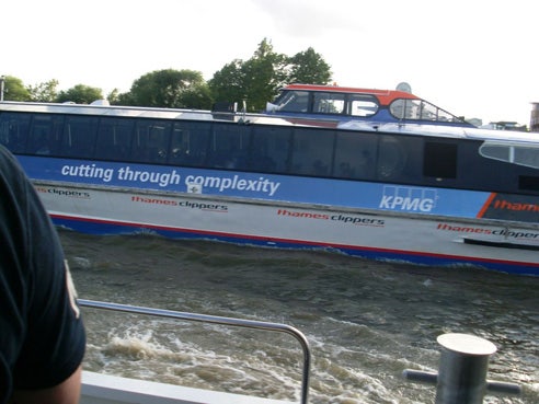 A boat on the river has 'cutting through complexity' printed on its side.