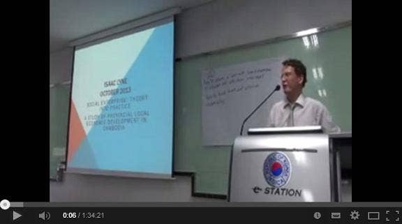 Isaac Lyne standing behind a lectern giving a presentation