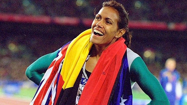 Cathy Freeman wearing the Australian and Indigenous flag