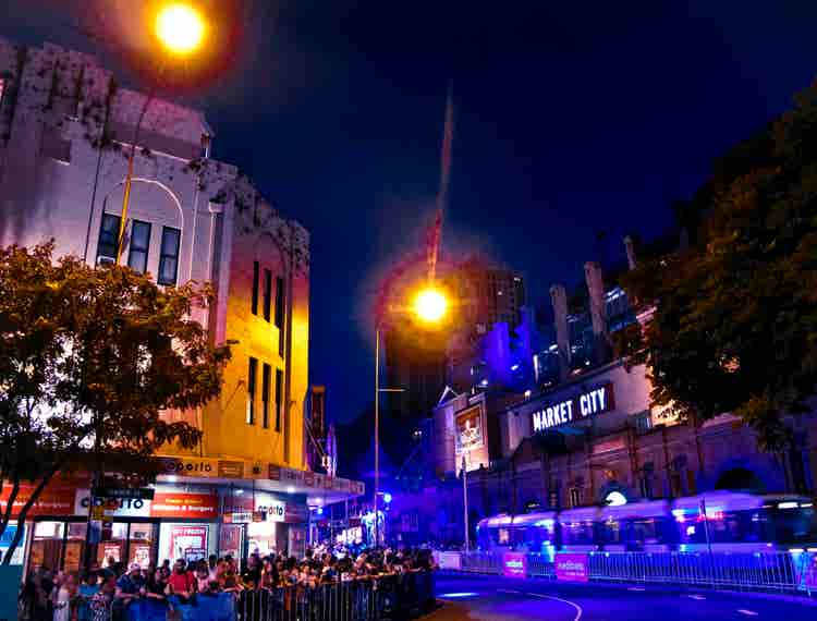 Market city at twilight with people and tram
