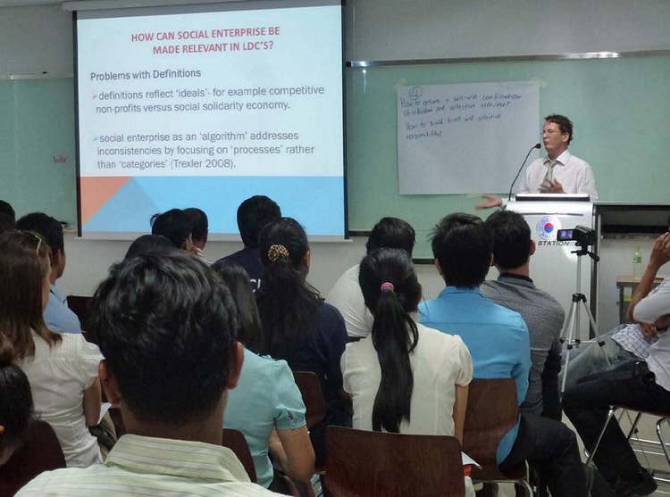 Isaac Lyne standing at lectern presenting in front of an audience