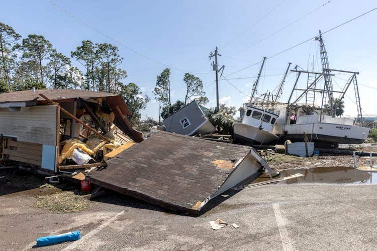 A building demolished by a hurricane, with downed power lines in the background.
