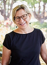 Dr Megan Watkins with trees and the Female Orphan School in the background.