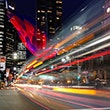 Thumbnail image of city at night with streaming lights of a bus in movement.