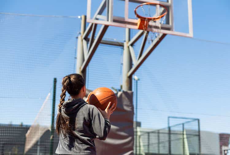 Girl shooting basketball AdobeStock by Angelov
