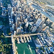 A photo of Sydney city taken from the air - shows Circular Quay and Botanical Gardens and is looking towards the CBD.