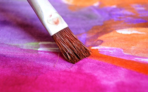 A brush painting bright colours on paper. Image by Uwe Baumann from Pixabay.