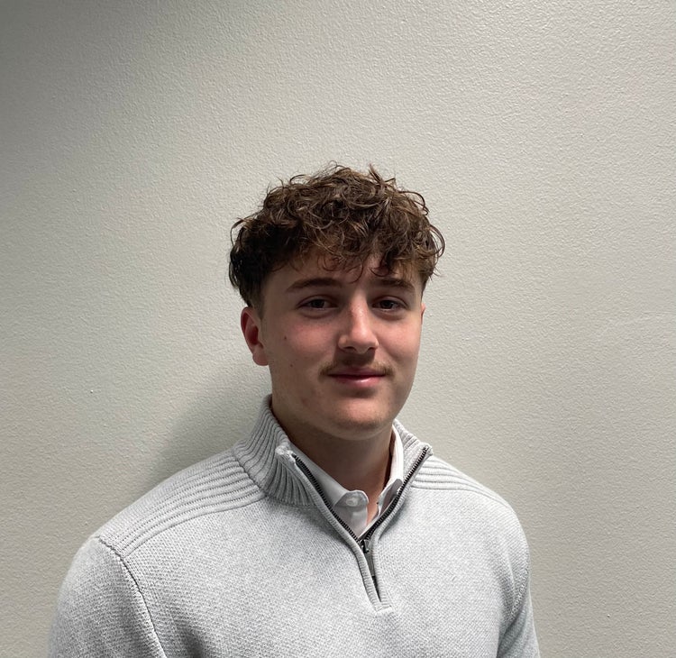 photo of person looking at the camera, short brown hair, light gray top