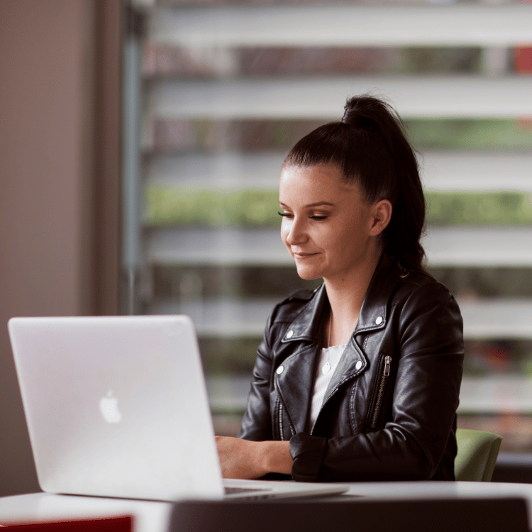 Student sitting on a table with a laptop