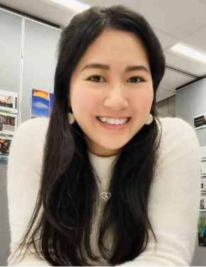 A person smiling at the camera Description automatically generated