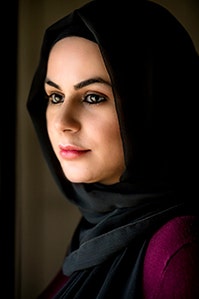 A colour photo of Raaza, wearing a burgundy shirt and black hijab