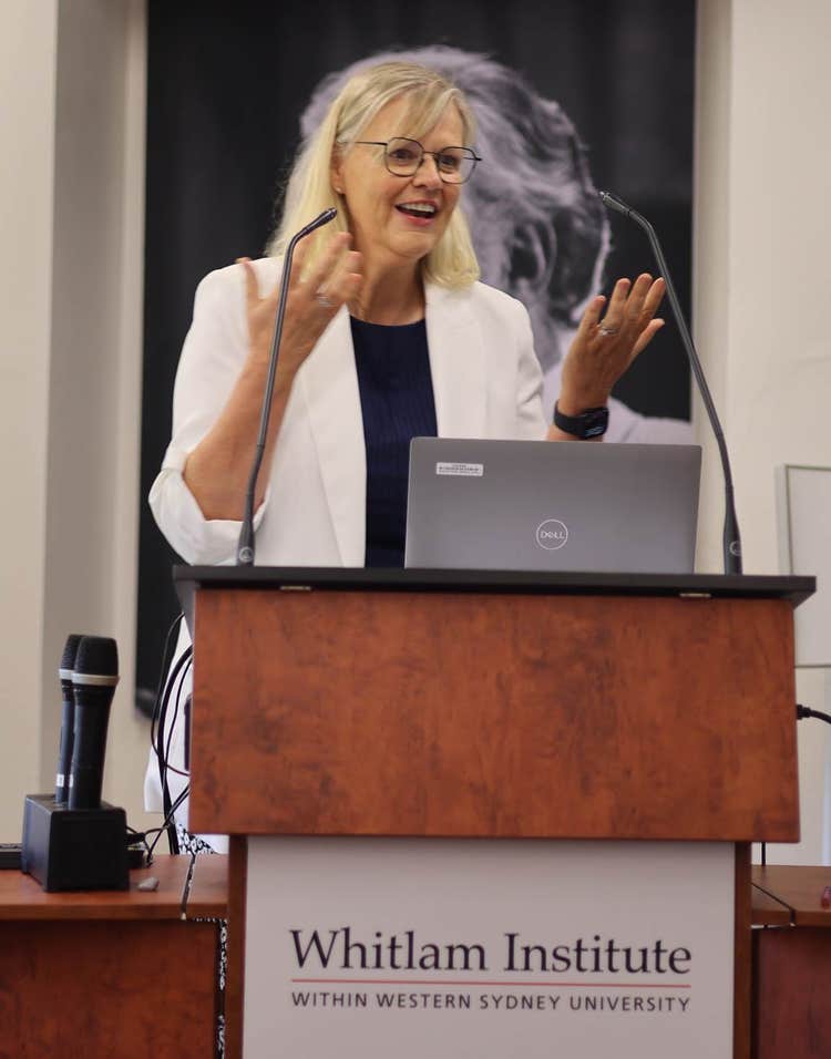 A person standing at a podium with microphones